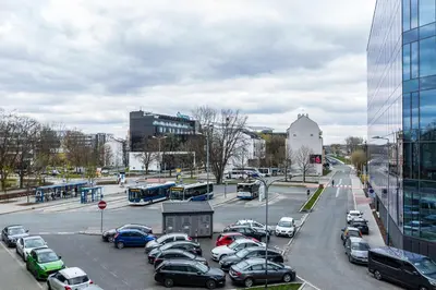 a parking lot with cars parked in a city at Cloud9 - Barska 69 in Kraków