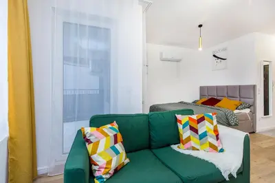 a living room with a green couch with colorful pillows at Cloud9 - Barska 69 in Kraków