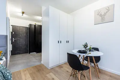 a living room with a table and chairs in a room at Cloud9 - Barska 69 in Kraków