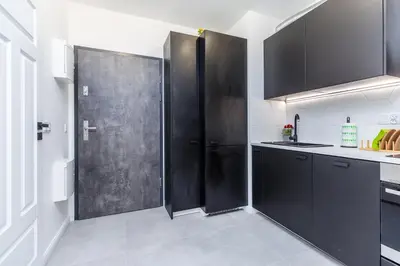 a kitchen with black cabinets and a sliding door at Cloud9 - Barska 69 in Kraków