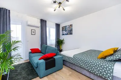 a bedroom with a bed and a blue chair at Cloud9 - Barska 69 in Kraków