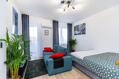 a bedroom with a bed and a blue chair at Cloud9 - Barska 69 in Kraków