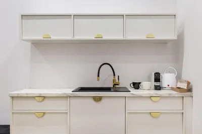 a kitchen with white cabinets and a sink at Oro Apartments in Kraków