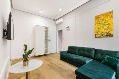 a living room with a green couch and a table at Oro Apartments in Kraków