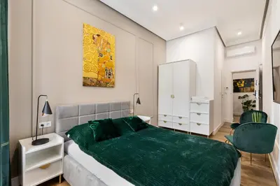 a bedroom with a bed with a green blanket at Oro Apartments in Kraków