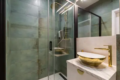 a bathroom with a sink and a glass shower at Oro Apartments in Kraków