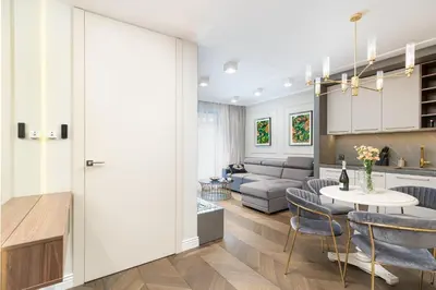 a kitchen and living room with a table and chairs at Glossy Apart G244 in Kraków