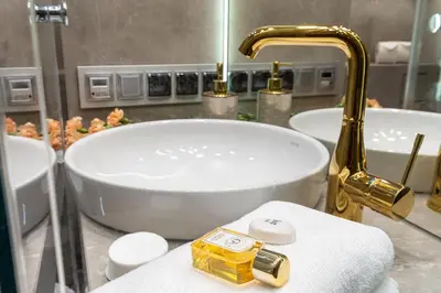 a bathroom with two tubs and a sink with a faucet at Glossy Apart G244 in Kraków