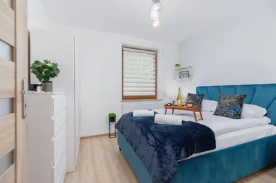 a bedroom with a blue bed and a window at Bunscha Apartment Dębniki Cracow by Noclegi Renters in Kraków
