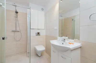 a bathroom with a toilet sink and a shower at Bunscha Apartment Dębniki Cracow by Noclegi Renters in Kraków