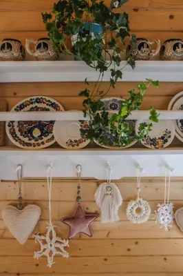 a shelf with dishes and ornaments on it at Alemiło - uroczy dom z balią i widokiem na Babią Górę in Zawoja