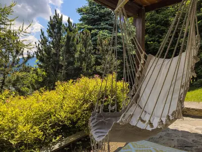 a hammock hanging from a porch at Alemiło - uroczy dom z balią i widokiem na Babią Górę in Zawoja