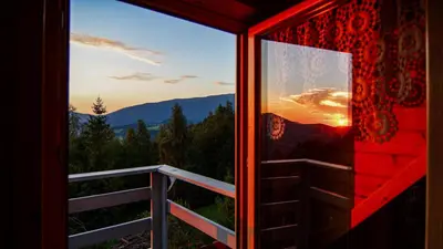a room with a window with a view of the sunset at Alemiło - uroczy dom z balią i widokiem na Babią Górę in Zawoja