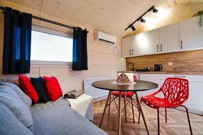 a balcony with a couch and a table and chairs at Holiday Park Zator Resort & Spa in Zator