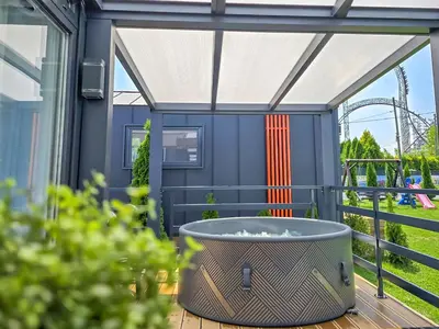 a patio with a table and chairs and a coaster at Holiday Park Zator Resort & Spa in Zator