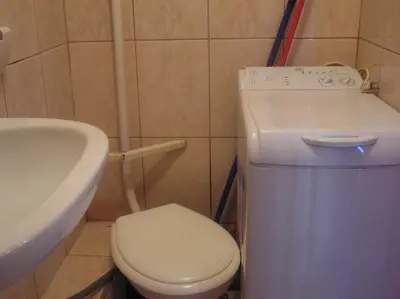 a small white refrigerator in a kitchen with a table at A-klimatyzacja kawalerka mała Halczyna 9 do Centrum 6 przystanków in Kraków