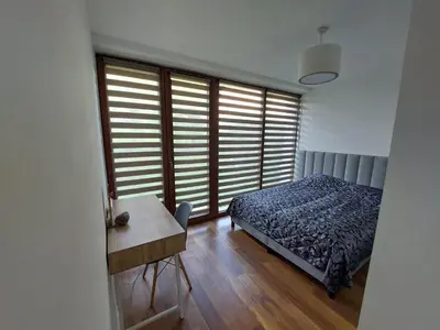 a bedroom with a bed and a table and a window at Apartament Reformacka in Wieliczka