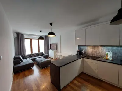 a kitchen and a living room with a couch at Apartament Reformacka in Wieliczka