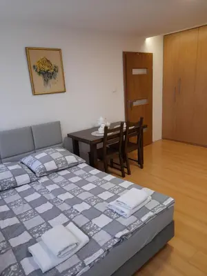 a bedroom with a bed with a yellow pillow and a television at Apartament 44 in Wadowice