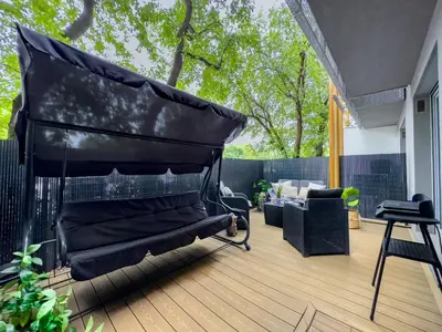 a patio with a black umbrella on a deck at Apartament z dużym tarasem w centrum Krakowa in Kraków