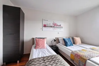 a bedroom with two beds and a painting on the wall at Urban Nest Apartments Starowiślna 95 in Kraków