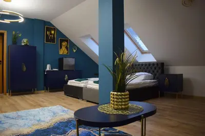 a bedroom with blue walls and a table and a bed at Mały Książę in Podzamcze