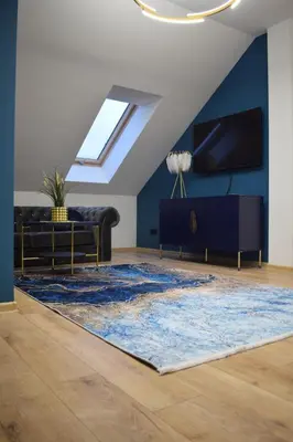 a living room with a couch and a rug at Mały Książę in Podzamcze