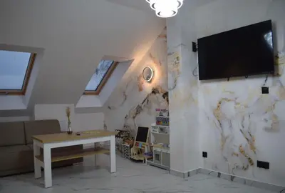 a living room with a tv on a wall at Mały Książę in Podzamcze