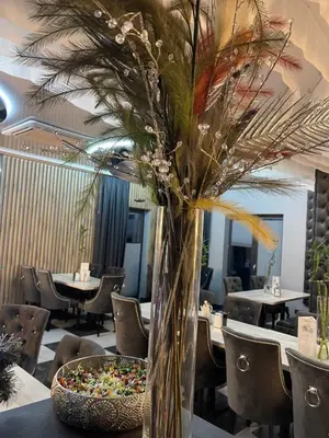a vase of flowers sitting on a table in a restaurant at Mały Książę in Podzamcze