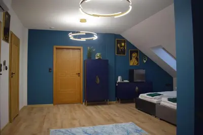 a room with a blue wall with a bed and a door at Mały Książę in Podzamcze