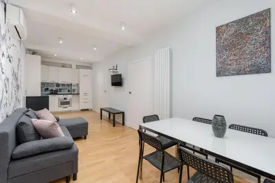 a kitchen and living room with a table and chairs at S18 Boutique Residence - Krakow Old Town in Kraków