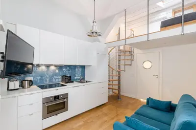 a kitchen with white cabinets and a blue couch at S18 Boutique Residence - Krakow Old Town in Kraków