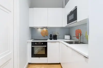 a white kitchen with a stove and a sink at S18 Boutique Residence - Krakow Old Town in Kraków