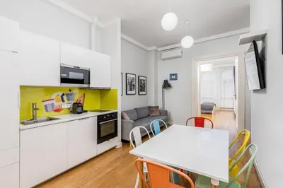 a kitchen and living room with a table and chairs at S18 Boutique Residence - Krakow Old Town in Kraków