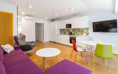 a living room with a purple couch and a table and chairs at S18 Boutique Residence - Krakow Old Town in Kraków