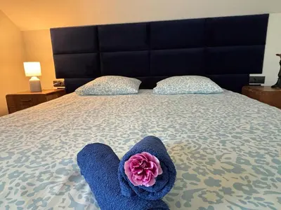 a bed with blue towels and a pink flower on it at Beskid Family&Chill in Tenczyn
