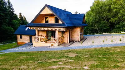 a small log cabin with a blue roof at Chałupy w Lesie Skawinki in Skawinki