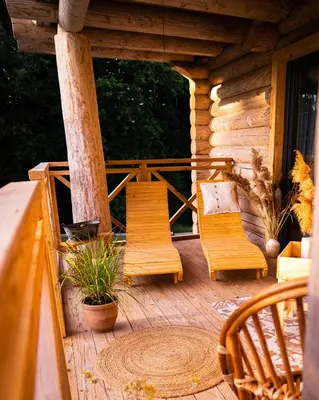 a porch of a log cabin with two chairs at Chałupy w Lesie Skawinki in Skawinki