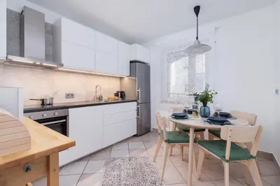 a kitchen with a table and chairs in a room at Apartment Home Office Dobrego Pasterza Kraków by Noclegi Renters in Kraków