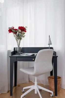 a desk with a chair and a vase with red roses at Apartment Home Office Dobrego Pasterza Kraków by Noclegi Renters in Kraków