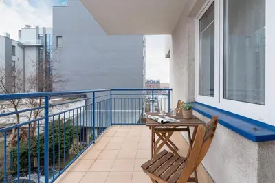 a balcony with a wooden table and a chair at Apartment Home Office Dobrego Pasterza Kraków by Noclegi Renters in Kraków