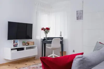 a living room with a tv and a desk with a chair at Apartment Home Office Dobrego Pasterza Kraków by Noclegi Renters in Kraków