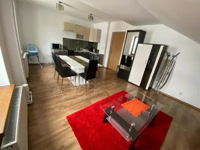 a living room with a table and a red rug at Apartament Polański z tarasem na dachu in Rabka