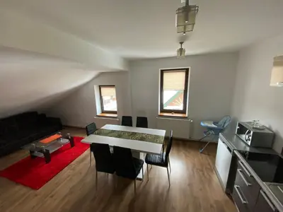 a living room with a table and a couch at Apartament Polański z tarasem na dachu in Rabka