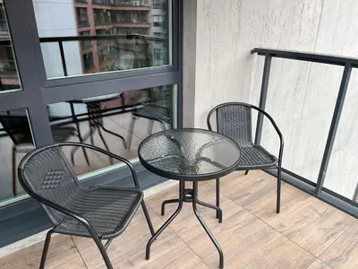 two chairs and a glass table on a balcony at PM. Apartments Krakow in Kraków