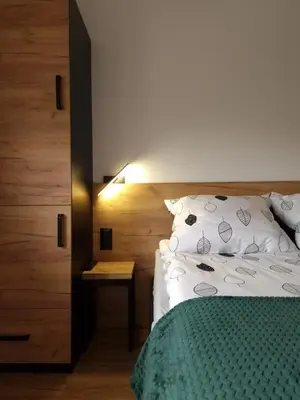 a bedroom with a bed and a nightstand next to a bed at Bulwary Mszańskie - Pokoje in Mszana Dolna