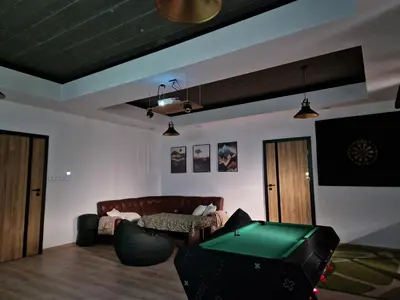 a living room with a couch and a pool table at Bulwary Mszańskie - Pokoje in Mszana Dolna
