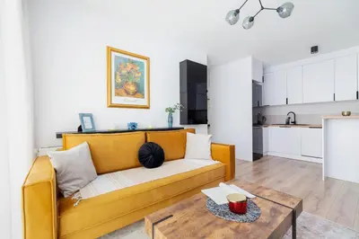 a living room with a yellow couch and a table at Tauron Arena Premium Apartment with Underground & Outdoor Parking by Renters Prestige in Kraków