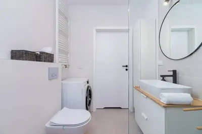 a white bathroom with a toilet and a mirror at Tauron Arena Premium Apartment with Underground & Outdoor Parking by Renters Prestige in Kraków