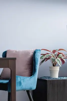 a blue chair sitting next to a table with a potted plant at Tauron Arena Premium Apartment with Underground & Outdoor Parking by Renters Prestige in Kraków